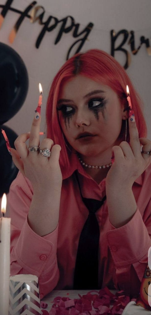 Jade in pink light holding two lit candles on her fingers